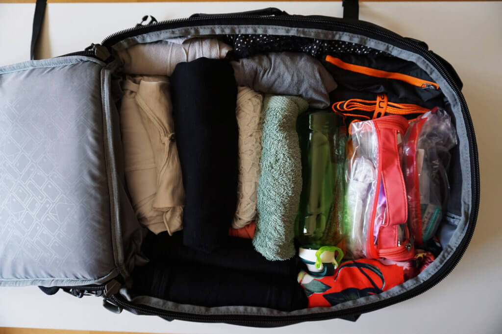 Ropa enrollada dentro de la mochila de viaje